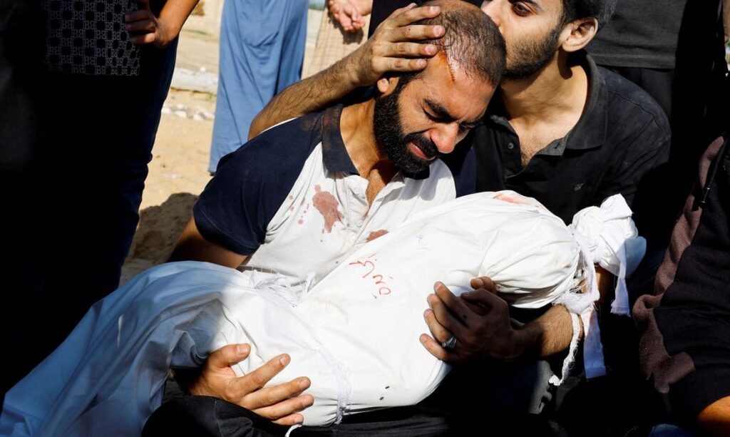 O pai de Alma Al Majayda, de 3 anos, morta em ataques israelenses, abraça seu corpo durante seu funeral, em meio ao conflito em curso entre Israel e o grupo islâmico palestino Hamas, em Khan Younis, no sul da Faixa de Gaza. 19 de outubro de 2023. REUTERS/Mohammed Salem