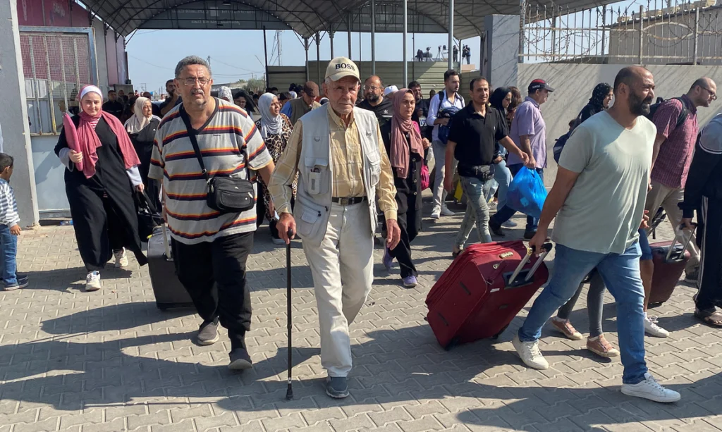 Palestinos com dupla cidadania caminham no posto fronteiriço de Rafah com o Egito, na esperança de obter permissão para deixar Gaza, em meio ao conflito em curso entre Israel e o grupo islâmico palestino Hamas, em Rafa, no sul da Faixa de Gaza, em 1º de novembro de 2023. REUTERS/Arafat Barbakh