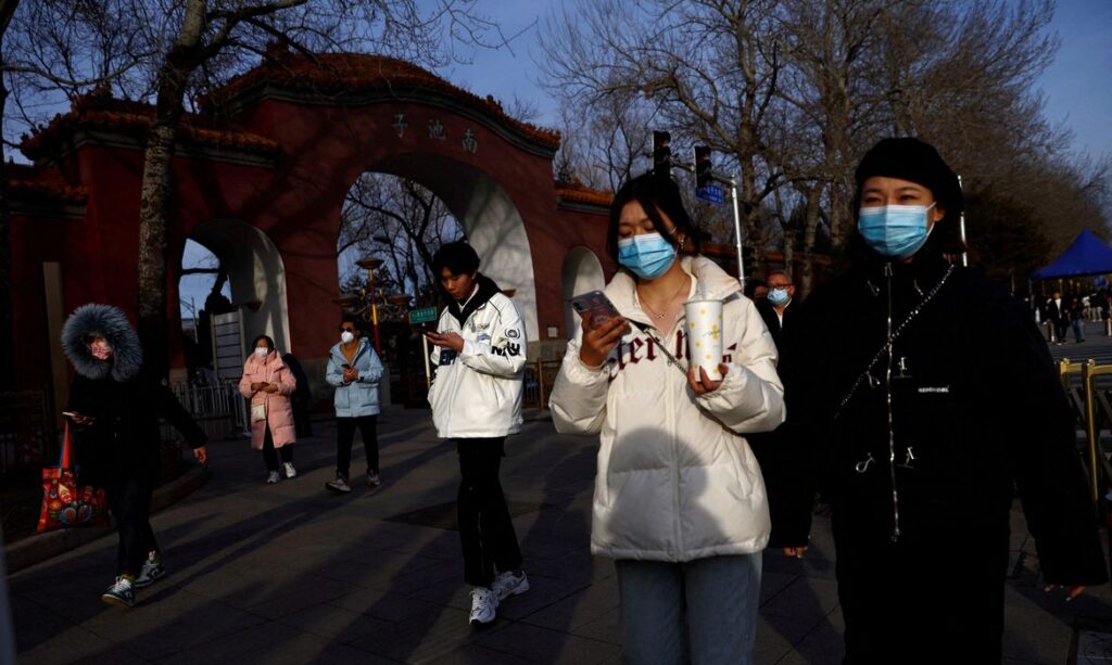 FILE PHOTO: People, wearing masks to prevent coronavirus disease (COVID-19), walk along the street in Beijing, China, February 14, 2023. REUTERS/Tingshu Wang/File Photo