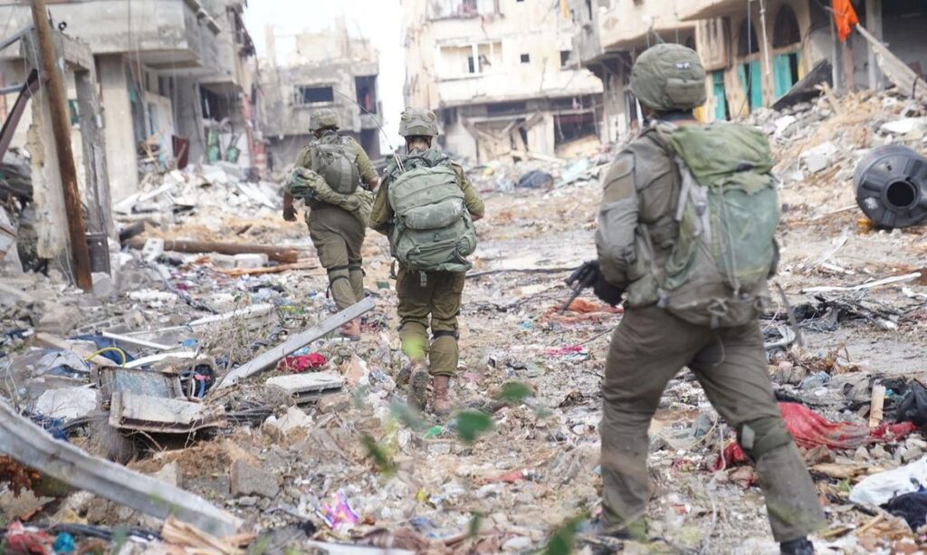 Israeli soldiers operate next to damaged buildings amid the ongoing ground operation of the Israeli army against the Palestinian Islamist group Hamas, in the Gaza Strip, in this handout image released November 18, 2023. Israel Defense Forces/Handout via REUTERS THIS IMAGE HAS BEEN SUPPLIED BY A THIRD PARTY