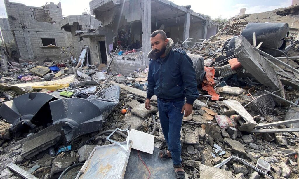 Palestino Ibrahim Al-Haj Youssef, que perdeu quatro de seus filhos e sua esposa em um ataque aéreo israelense, está entre os escombros, no campo de Maghazi
25/12/2023
REUTERS/Doaa Ruqaa