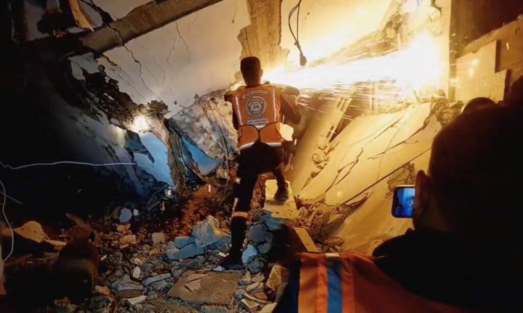 A screen grab taken from a video posted on social media by the Palestinian Civil Defence on December 5, 2023, shows what they say are members of the Palestinian Civil Defence rescue team working in a collapsed building in a location given as Gaza. Palestinian Civil Defence/Handout via REUTERS    THIS IMAGE HAS BEEN SUPPLIED BY A THIRD PARTY. MANDATORY CREDIT. NO RESALES. NO ARCHIVES.