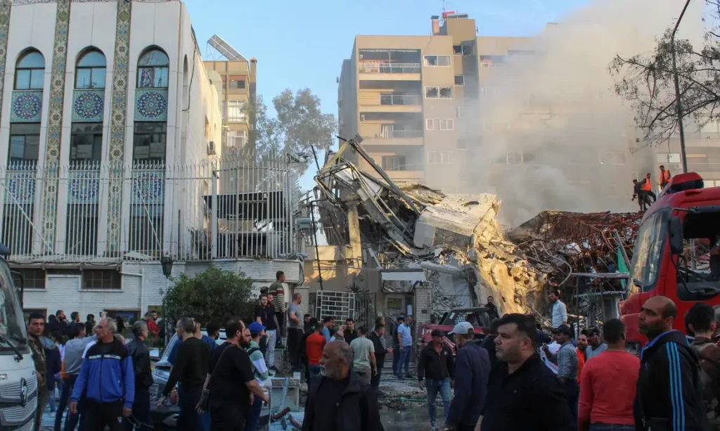 People gather near a damaged site after what Syrian and Iranian media described as an Israeli air strike on Iran's consulate in the Syrian capital Damascus April 1, 2024. REUTERS/Firas Makdesi