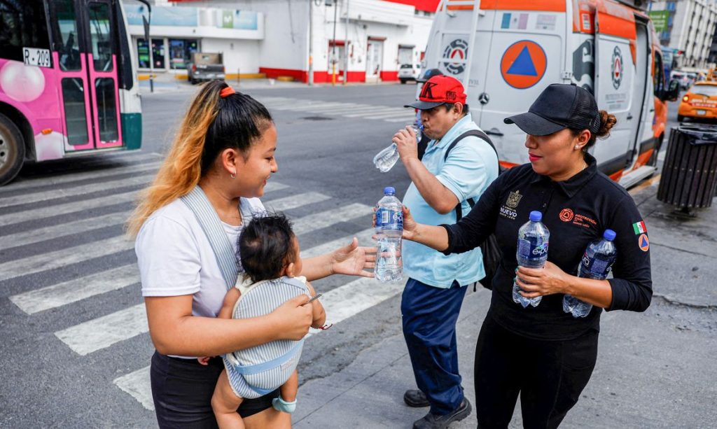 Civil Protection members hand out bottles of cold water during a heat wave, in Monterrey, Mexico May 9, 2024. REUTERS/Daniel Becerril
