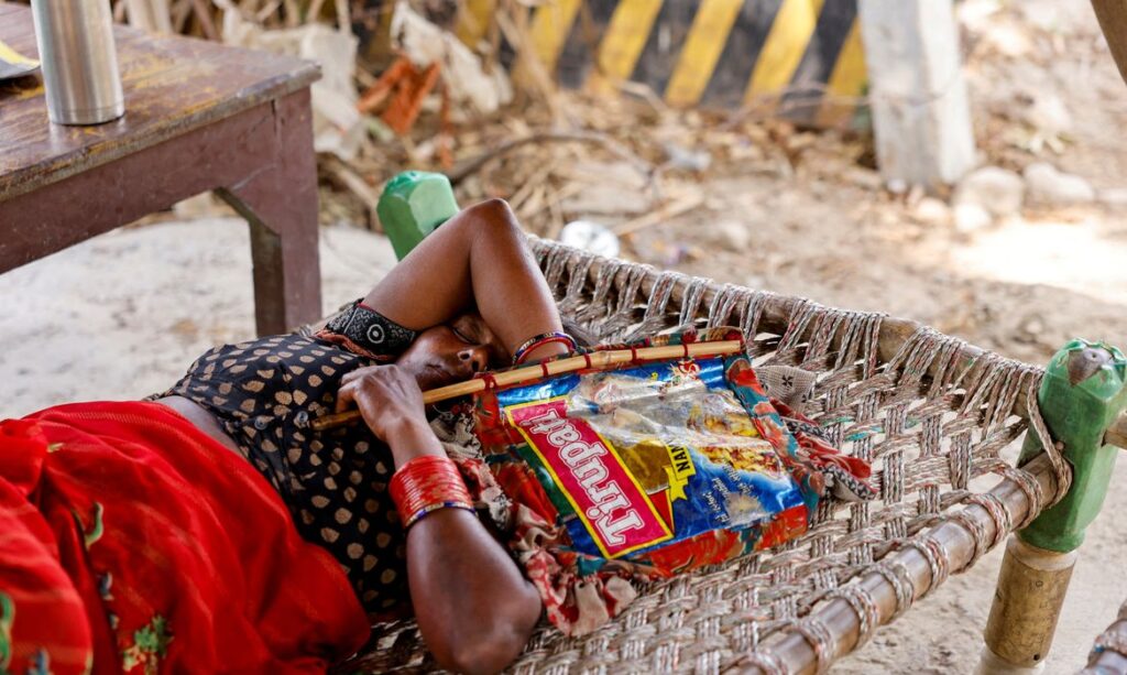 A trabalhadora agrícola Khilona, ​​de 50 anos, dorme em cama com leque feito à mão sob um galpão em sua casa, nas planícies aluviais de Yamuna, em um dia quente de verão durante onda de calor 
30/05/2024
REUTERS/Anushree Fadnavis