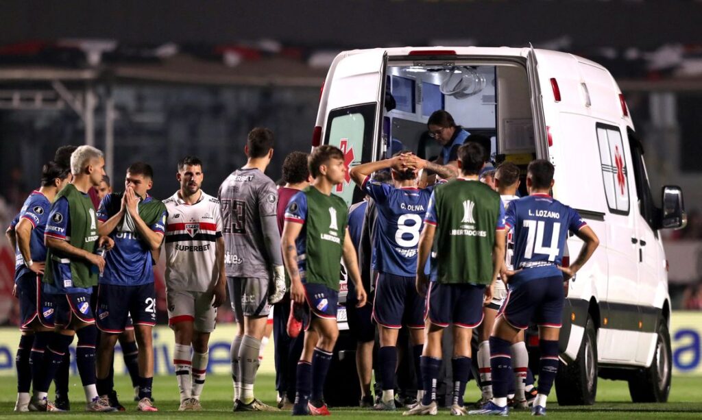 Jogadores de Nacional e São Paulo acompanham atendimento ao zagueiro Juan Izquierdo, do Nacional, após entrada de ambulância no gramado durante partida entre as duas equipes pela Copa Libertadores em São Paulo
22/08/2024 REUTERS/Carla Carniel