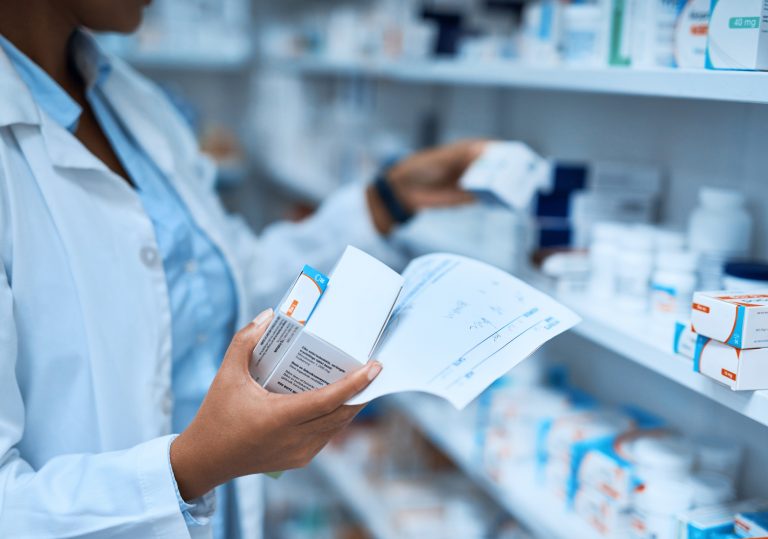 Pessoa separa medicamentos em farmácia