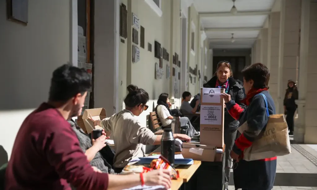 Polling station staff sit as a woman casts her vote during the legislative elections in Buenos Aires Province, in La Plata, Argentina, September 7, 2025. Reuters/Tomas Cuesta/Proibida reprodução