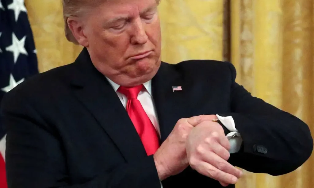 FILE PHOTO: U.S. President Donald Trump checks his watch during an event to celebrate federal judicial confirmations in the East Room of the White House in Washington, D.C., U.S., November 6, 2019. REUTERS/Jonathan Ernst/File Photo