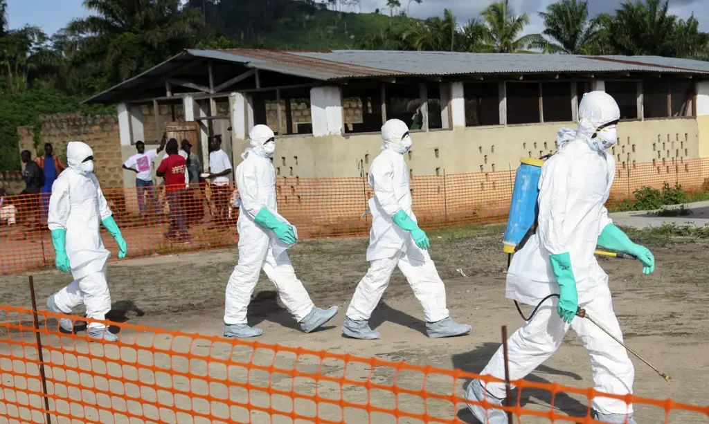epa04332724 A photograph made available 27 July 2014 shows Liberian health workers in protective gear on the way to bury a woman who died of the Ebola virus from the isolation unit in Foya, Lofa County, Liberia, 02 July 2014. Over 660 people have died of Ebola in West Africa in 2014 making it the world's deadliest outbreak to date. Nigerian authorities have confirmed the death of a Liberian man who was carrying the Ebola virus making it the first case in Nigeria following the outbreak in Guinea, Sierra Leone and Liberia.  EPA/AHMED JALLANZO