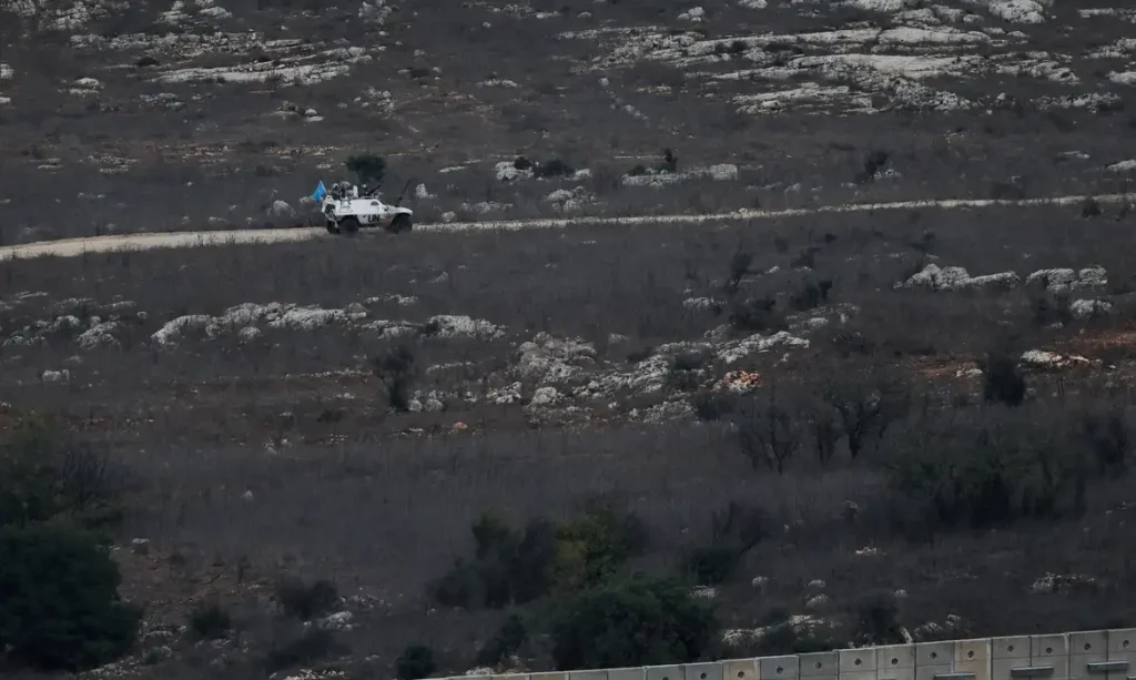 A UN vehicle drives near a concrete wall along Lebanon's southern border which, according to the Lebanese presidency, extends beyond the