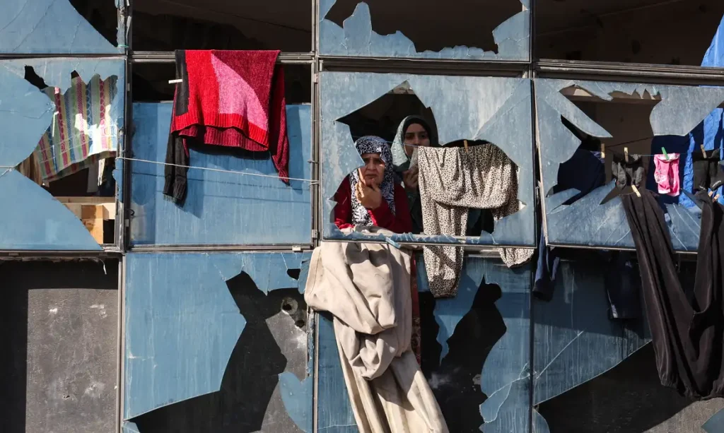 Palestinian women look on from behind broken windows, during the funeral of Palestinians who, according to medics, were killed by an Israeli strike on Saturday, at Al-Shifa Hospital in Gaza City, January 31, 2026. REUTERS/Dawoud Abu Alkas