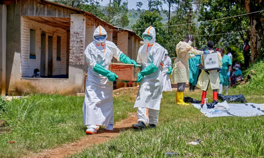 Red Cross workers wearing personal protective equipment (PPE) carry a coffin with the dead body of a child who died of Ebola, as aid agencies intensify efforts to contain a new Ebola outbreak involving the Bundibugyo strain in Mongbwalu, Djugu Territory, Ituri province, Democratic Republic of Congo, May 24, 2026. The child's parents remain at the isolation centre at the Mongbwalu General Referral Hospital. REUTERS/Gradel Muyisa Mumbere