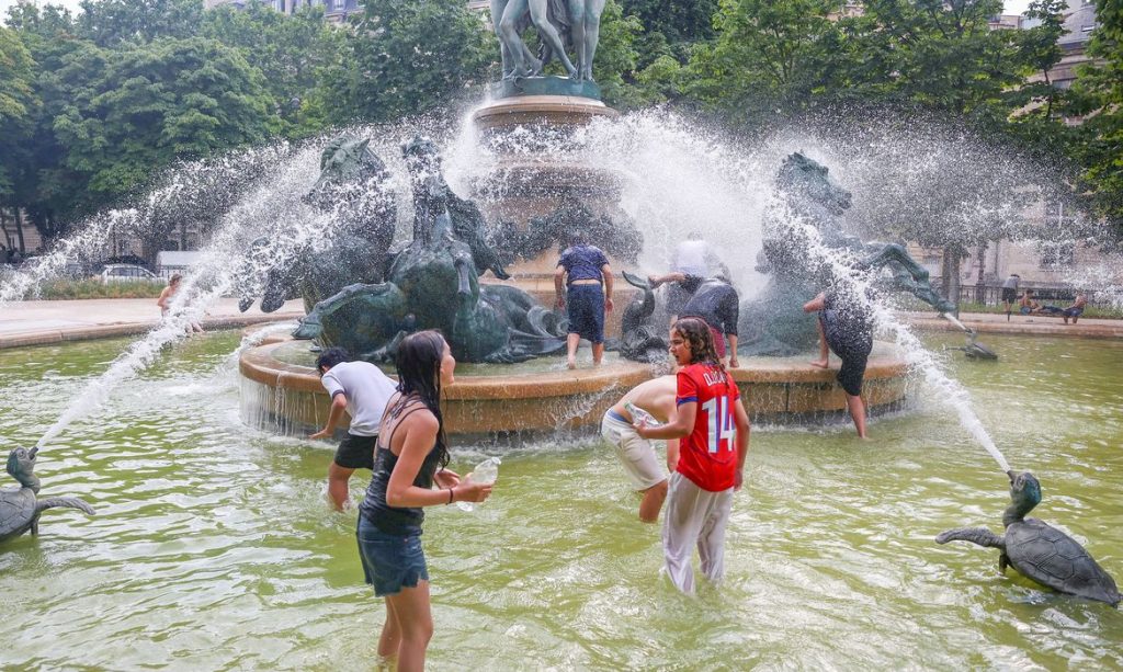 Young people cool off in the Fontaine de l'Observatoire fountain as temperatures rise in Paris and a heatwave hits a large part of France, June 18, 2026. REUTERS/Abdul Saboor