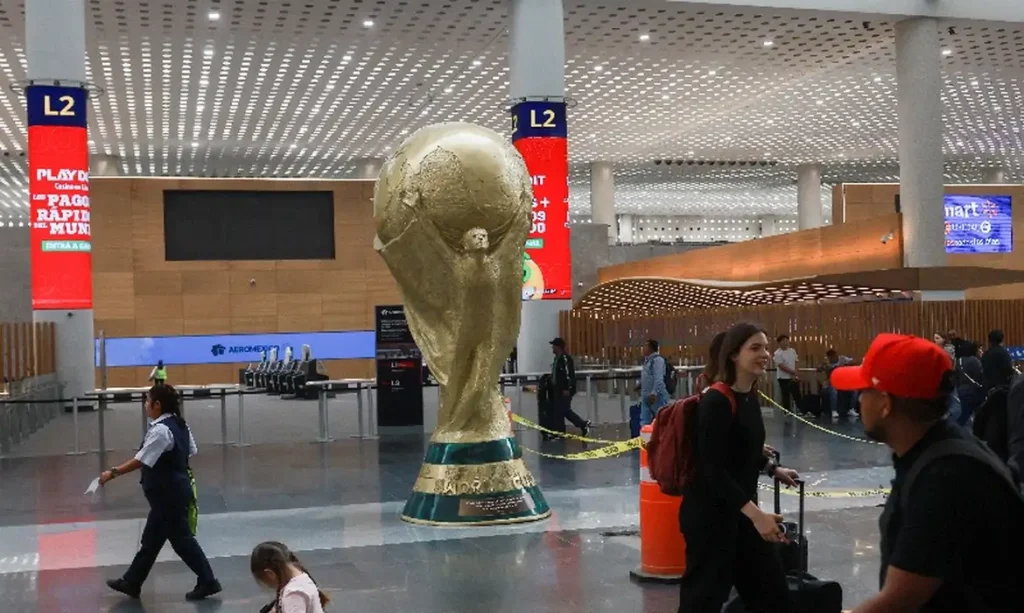 Passageiros passam por réplica gigante do troféu da Copa do Mundo no Aeroporto Internacional da Cidade do México 
 18 de maio de 2026    REUTERS/Henry Romero