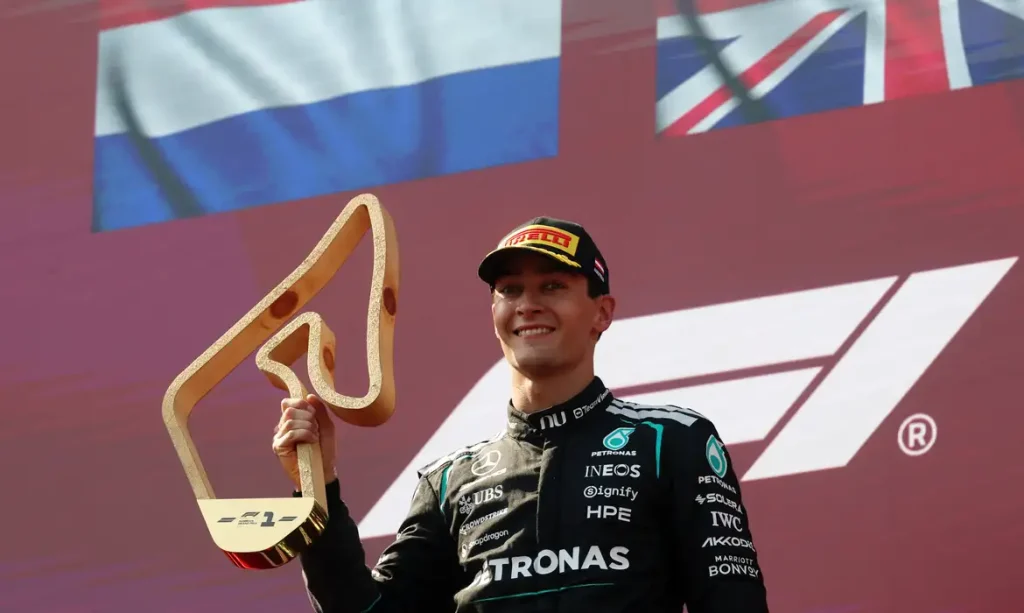 George Russell, da Mercedes, comemora com o troféu no pódio após vencer o Grande Prêmio da Áustria, 28 de junho de 2026. REUTERS/Leonhard Foeger