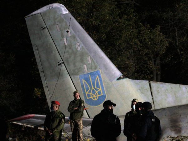 Soldados guardam destroços de aeronave militar que caiu na Ucrânia nesta sexta (25) — Foto: Sergey Bobok/AFP