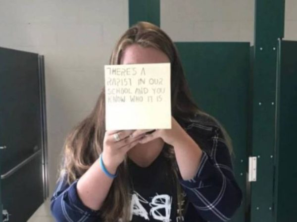 Aela Mansmann com um post-it escrito: 'Há um estuprador em nossa escola e você sabe quem é' — Foto: Reprodução Facebook