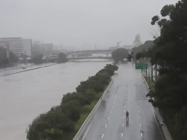 Um homem caminha sobre uma via expressa marginal parcialmente inundada do Tietê após fortes chuvas em São Paulo, Brasil, 10 de fevereiro de 2020. REUTERS / Rahel Patrasso