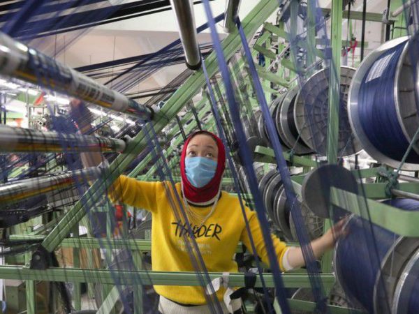 Funcionário de fábrica chinesa trabalha com máscara de proteção