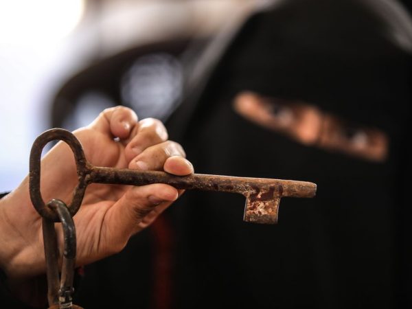 A Palestinian woman holds a key during a demonstration ahead of the 74th anniversary of the Nakba, the