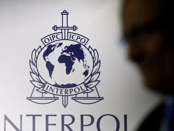 FILE PHOTO: A man passes an Interpol logo during the handing over ceremony of the new premises for Interpol's Global Complex for Innovation, a research and development facility, in Singapore September 30, 2014. REUTERS/Edgar Su//File Photo