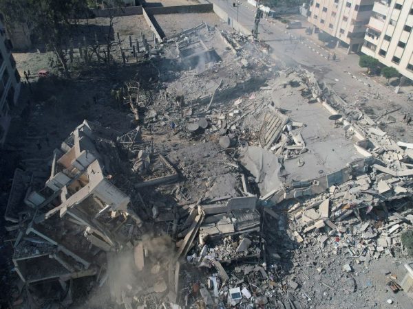 Palestinos se reúnem em torno de prédios residenciais destruídos em ataques israelenses na cidade de Zahra, em meio ao conflito em curso entre Israel e o grupo islâmico palestino Hamas, ao sul da Cidade de Gaza. 19 de outubro de 2023. REUTERS/Shadi Tabatibi