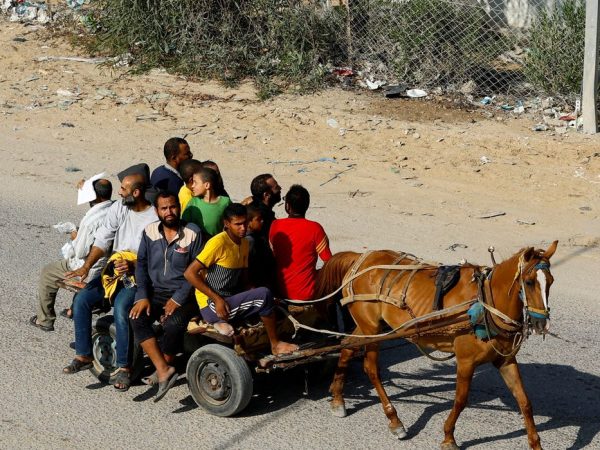 Palestinian workers who were in Israel during the Hamas October 7 attack, are transported on a horse-drawn cart, amid fuel shortages, as they arrive at the Rafah border, after being sent back by Israel to the strip, in the southern Gaza Strip, November 3, 2023. REUTERS/Ibraheem Abu Mustafa     TPX IMAGES OF THE DAY