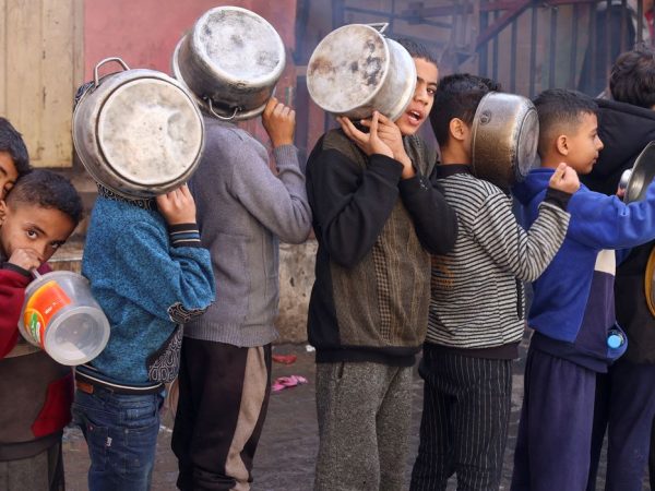 Crianças palestinas carregam panelas enquanto fazem fila para receber comida preparada em uma cozinha de caridade, em Rafah, no sul da Faixa de Gaza
14/12/2023
REUTERS/Saleh Salem