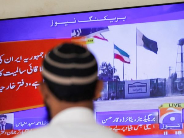 A man looks at a television screen after the Pakistani foreign ministry said the country conducted strikes inside Iran targeting separatist militants, two days after Tehran said it attacked Israel-linked militant bases inside Pakistani territory, in Karachi, Pakistan January 18, 2024. REUTERS/Akhtar Soomro