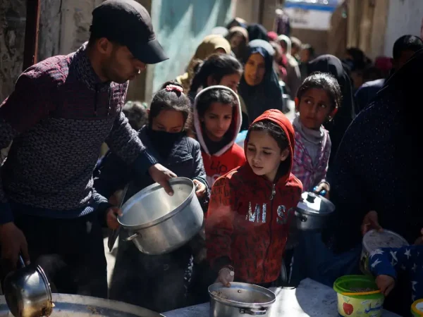 CRIANÇAS FOME GAZA - Palestinian children wait to receive food cooked by a charity kitchen amid shortages of food supplies, as the ongoing conflict between Israel and the Palestinian Islamist group Hamas continues, in Rafah, in the southern Gaza Strip, March 5, 2024. REUTERS/Mohammed Salem