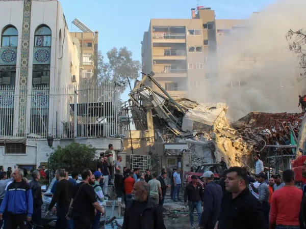 People gather near a damaged site after what Syrian and Iranian media described as an Israeli air strike on Iran's consulate in the Syrian capital Damascus April 1, 2024. REUTERS/Firas Makdesi