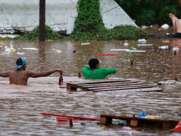 Pessoas caminham em área alagada às margens do Rio Taquari durante fortes chuvas em Encantado Rio Grande do Sul, Brasil, 2 de maio de 2024. REUTERS/Diego Vara
