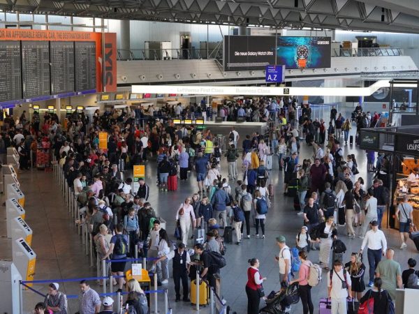 A display shows cancelled flights on the day activists of the