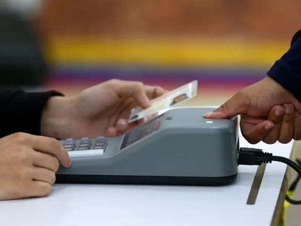 A woman is checked with a fingerprint identity registration device at a polling station in the Liceo Andres Bello during Venezuela's presidential election, in Caracas, Venezuela, July 28, 2024. REUTERS/Fausto Torrealba