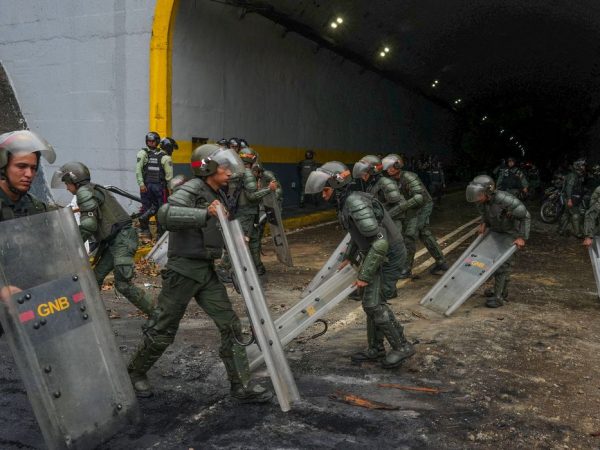 Members of the Bolivarian National Guard of Venezuela use their shields to clean an avenue after a protest from supporters of Venezuelan opposition following the announcement by the National Electoral Council that Venezuela's President Nicolas Maduro won the presidential election, in Caracas, Venezuela July 29, 2024. REUTERS/Alexandre Meneghini