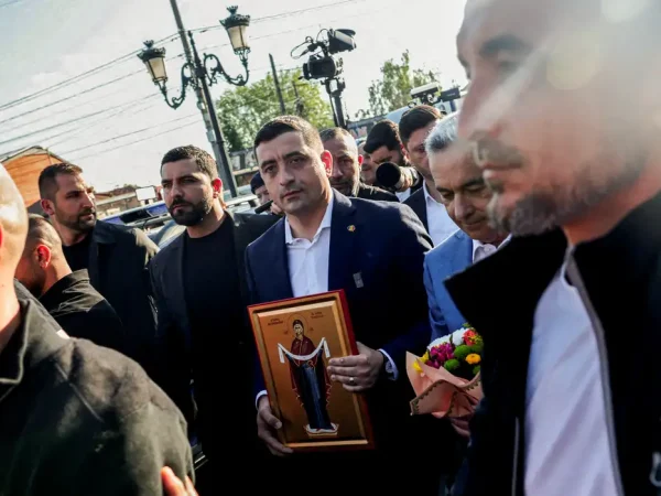 Presidential candidate George Simion walks holding a picture of Romanian holy icon of Protection of the Theotokos presented by a supporter outside a polling station during the country's first round of the presidential election, in Mogosoaia, Romania, May 4, 2025. REUTERS/Louisa Gouliamaki     TPX IMAGES OF THE DAY