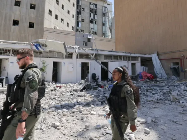 Members of the Israeli security forces walk near the Soroka Medical Center, the city's general hospital, at an impact site following a missile strike from Iran on Israel, in Beersheba, Israel on 19 June 2025.    Marc Israel Sellem/Pool via REUTERS