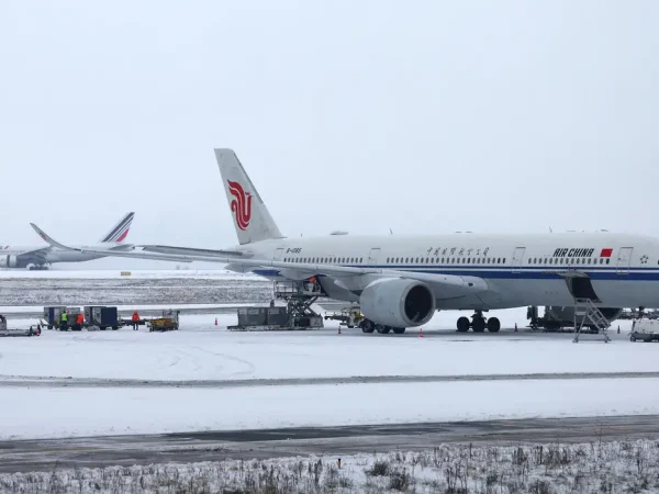 An Air China plane is seen on the snow-covered tarmac at the Paris CDG Terminal 1 of the Paris-Charles de Gaulle Airport, in Roissy-en-France, near Paris, as traffic is disrupted and some flights cancelled due winter weather with snow and cold temperatures on part of the country, France, January 7, 2026. REUTERS/Abdul Saboor