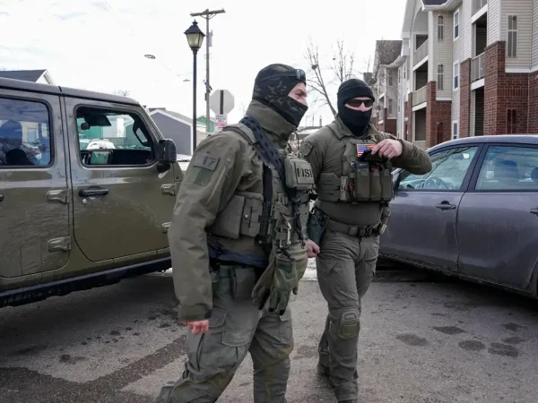 Homeland Security Investigations (HSI) agents stand next to their vehicle after stopping while conducting operations, following the fatal shooting of Renee Nicole Good by a U.S. Immigration and Customs Enforcement (ICE) agent, in a neighborhood in south Minneapolis, Minnesota, U.S., January 12, 2026. REUTERS/Seth Herald