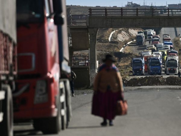 A woman walks among trucks stranded for days as protesters block a major highway, demanding the resignation of President Rodrigo Paz amid an ongoing economic and fuel crisis, in Apacheta, Bolivia, May 13, 2026. REUTERS/ Claudia Morales     TPX IMAGES OF THE DAY