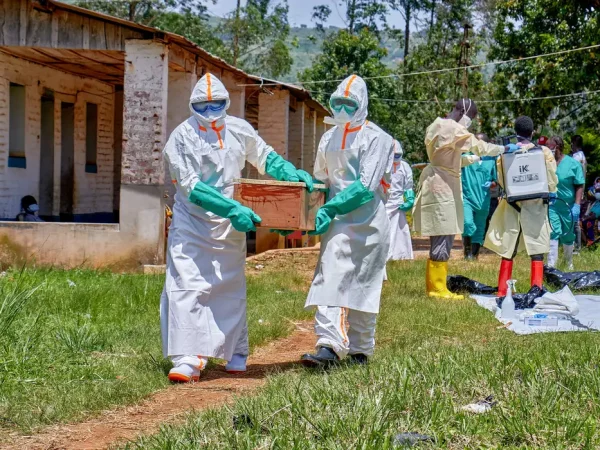 Red Cross workers wearing personal protective equipment (PPE) carry a coffin with the dead body of a child who died of Ebola, as aid agencies intensify efforts to contain a new Ebola outbreak involving the Bundibugyo strain in Mongbwalu, Djugu Territory, Ituri province, Democratic Republic of Congo, May 24, 2026. The child's parents remain at the isolation centre at the Mongbwalu General Referral Hospital. REUTERS/Gradel Muyisa Mumbere