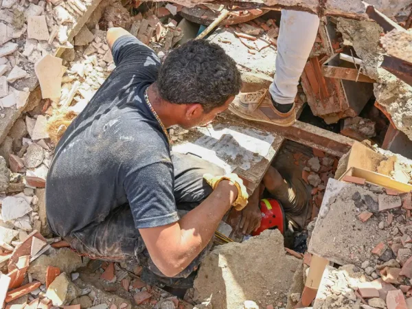 People work to rescue a man trapped under the rubble of a collapsed building, in the aftermath of earthquakes in La Guaira, Venezuela, June 25, 2026. REUTERS/Maxwell Briceno