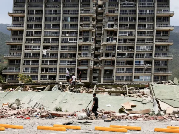 People inspect the rubble of a collapsed building after earthquakes hit the country, in La Guaira, Venezuela, June 25, 2026. REUTERS/Gaby Oraa      TPX IMAGES OF THE DAY