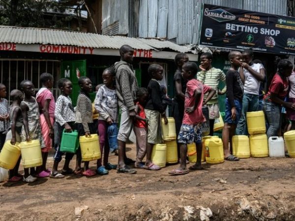 Crianças em fila aguardam a distribuição gratuita de água em Nairobi — Foto: AFP
