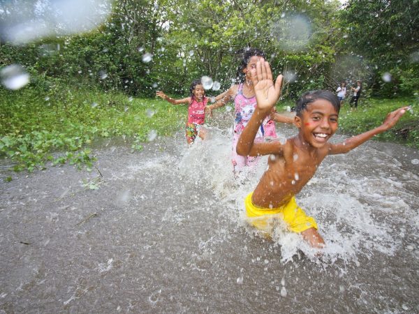 Crianças tomando banho com a água das chuvas (Foto: Reprodução)