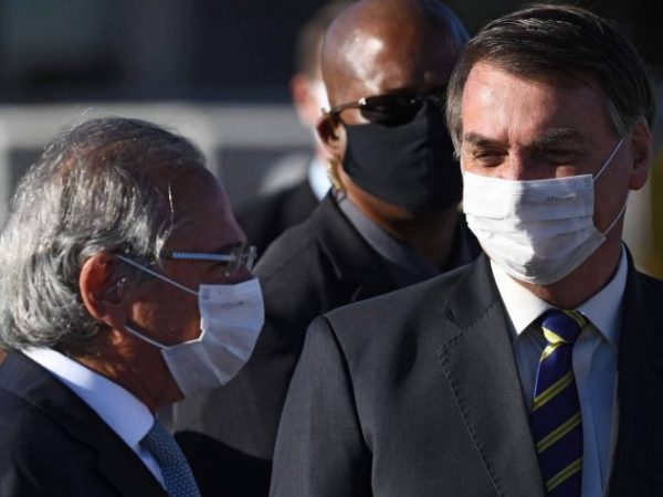 O ministro Paulo Guedes ao lado do presidente Jair Bolsonaro usando máscara antes de encontro ministerial — Foto: AFP