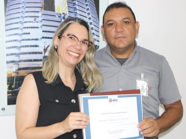 Psicóloga Tatiana Ferreira entrega certificado produzido pela empresa ao vigilante Marcone Oliveira, em Natal. — Foto: Cedida