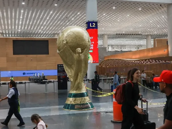 Passageiros passam por réplica gigante do troféu da Copa do Mundo no Aeroporto Internacional da Cidade do México 
 18 de maio de 2026    REUTERS/Henry Romero