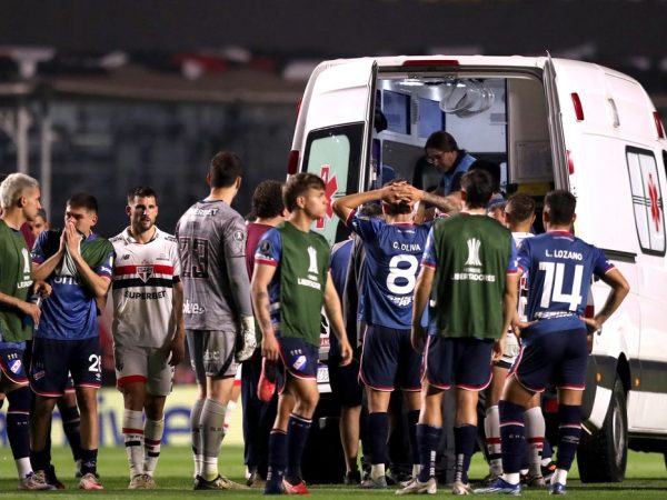 Jogadores de Nacional e São Paulo acompanham atendimento ao zagueiro Juan Izquierdo, do Nacional, após entrada de ambulância no gramado durante partida entre as duas equipes pela Copa Libertadores em São Paulo
22/08/2024 REUTERS/Carla Carniel